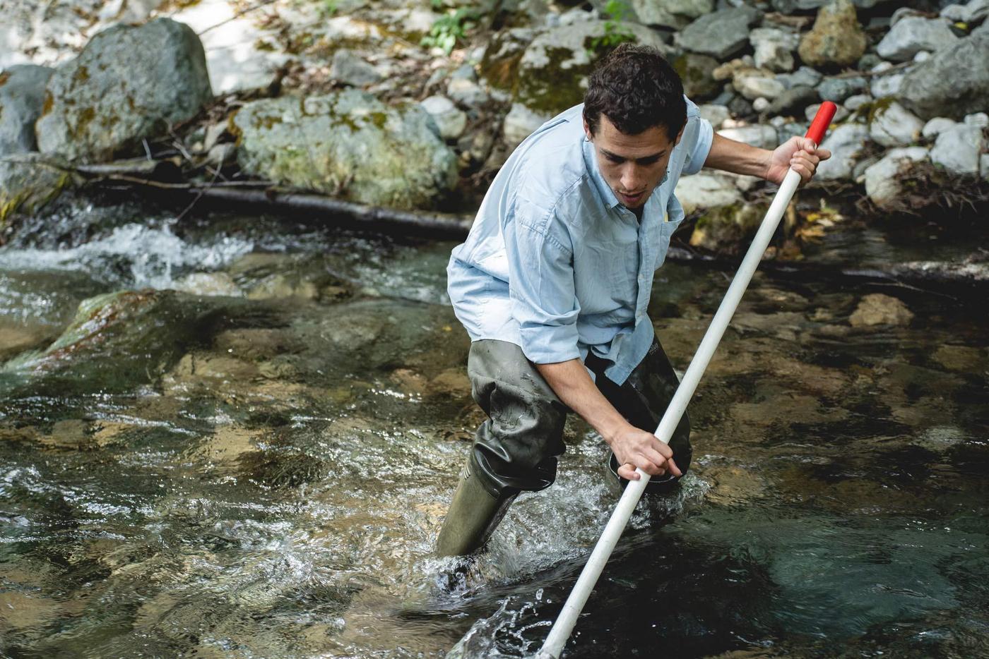 Fanourios Nikolaos Sakellarakis Fanikos Sakellarakis in rubber boots stands in the river and fishes with a scoop net.